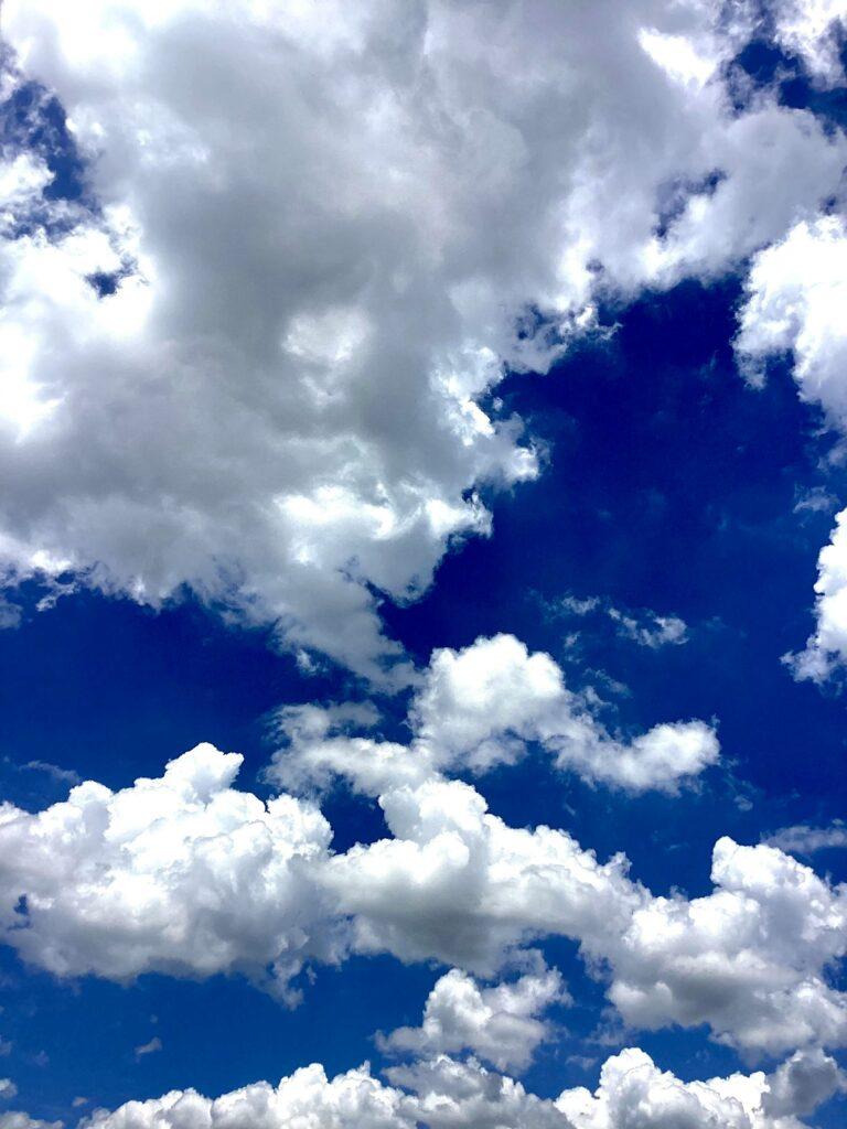 Bright white clouds over a vivid deep blue sky
